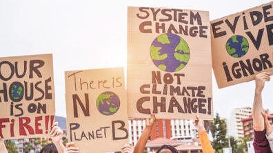 Protesters hold up signs about climate change