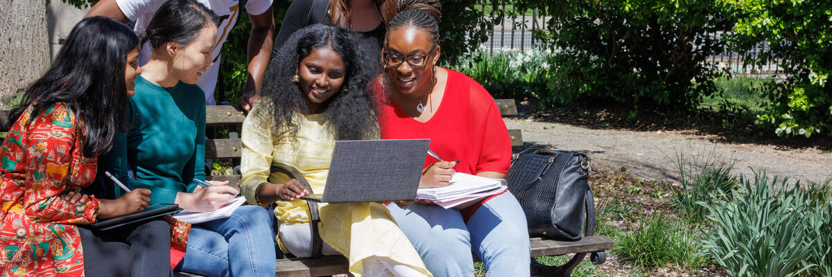 students on a bench studying together